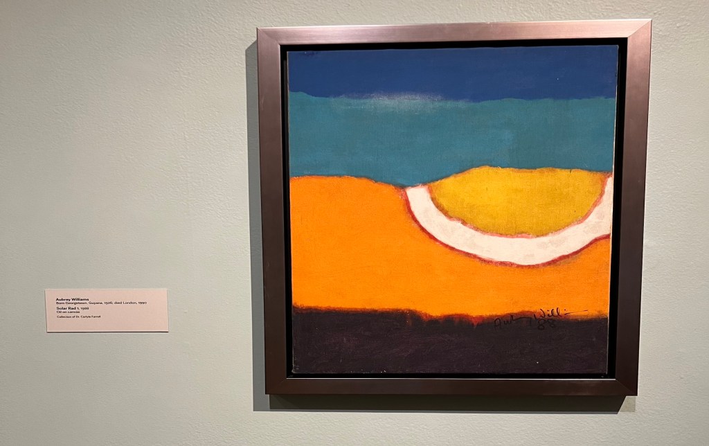 Colorful, abstract framed painting hanging on a wall with exhibit label.